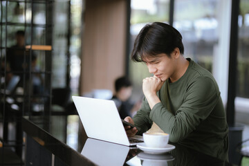 A young Asian man works at a coffee shop during the weekend.