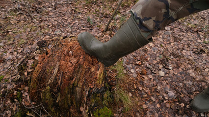 Feet in rubber boots on a forest, rural road.