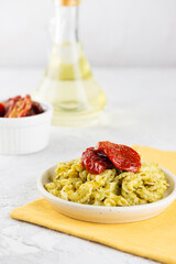 Italian pasta Creste Di Gallo with sun-dried tomatoes and pesto sauce. Vertical orientation.