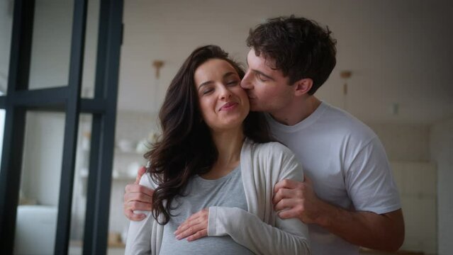 Portrait rent own home moving day relocation health medicine insurance loan mortgage smiling happy family couple pregnant Caucasian woman baby anticipation man kiss girl guy female male hug pregnancy