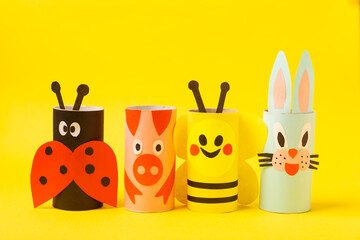 Fototapeta premium Toilet paper crafts on a colored background. Kids crafts made with toilet paper roll. DIY. Handmade. Paper toys. Origami animals. Concept of children's educational games. Place for text. Copy space.