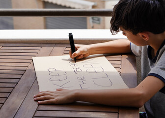 teenager writing a banner that reads 