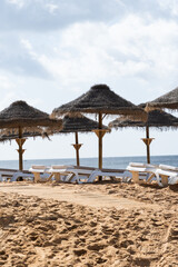 Straw chairs and umbrella. Praia do Peneco beach, Albufeira, Algarve, Portugal. Praia dos Pescadores beach. Fishermen, sunny day