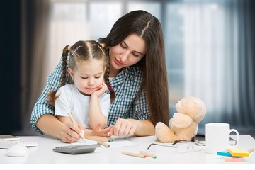 Young woman do homework with small child