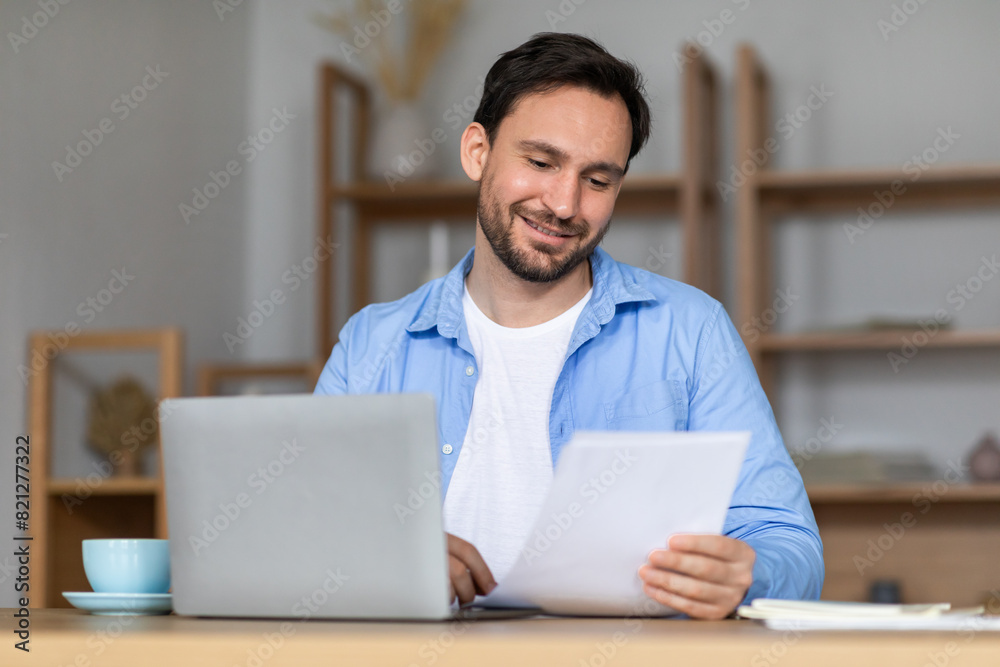 Aufkleber a man is seated at a table, surrounded by papers and a laptop. he appears focused and engaged in his