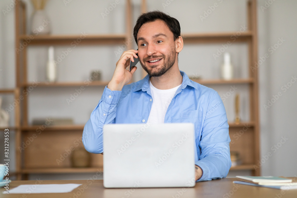 Aufkleber a man sitting at a desk, engaged in a phone conversation. he is multitasking, with a laptop open in 