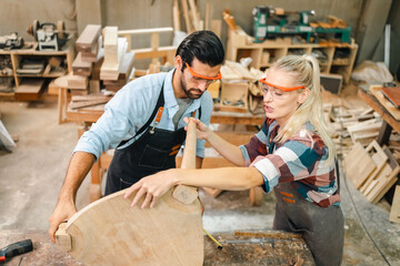 Attractive middle aged woman carpenter designer works with ruler, make notches on the tree in workshop. Image of modern femininity. Concept of professionally motivated women