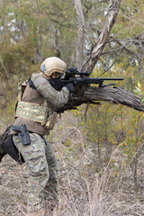 Naklejka premium Soldier airsoft player dressed in camouflage uniform wielding a sniper rifle