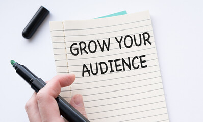 Note with the message of share your audience, with desk background