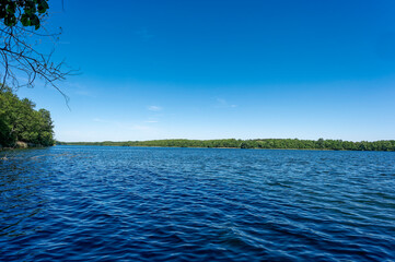 View over a lake with dark blue water to the opposite shore.