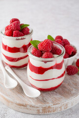 Vanilla white chocolate mousse, trifle, panna cotta or parfait with raspberry sauce in a glass jar. Sweet summer dieting dessert.