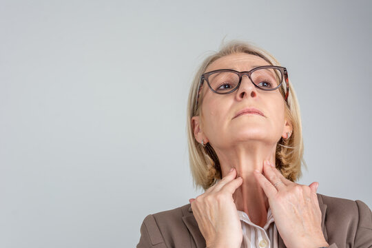 Woman thyroid gland control. Senior lady sweeping the laryngeal, laryngitis, goiter or Hypothyroidism. Disorder of the endocrine system. Hashimoto&rsquo;s Thyroiditis, Lymphocytic Thyroiditis.	