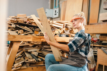 Attractive middle aged woman carpenter designer works with ruler, make notches on the tree in...