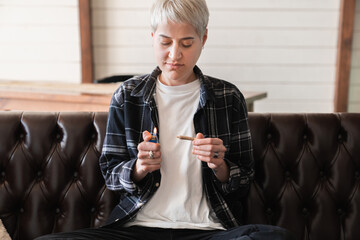 Young hipster woman girl lighting up marijuana cannabis joint with lighter. Marihuana tobacco...