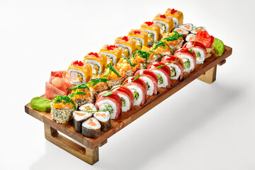 Delicious set of assorted sushi rolls on wooden tray