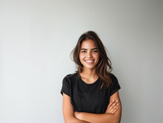 Obraz premium Beautiful natural brunette woman, smiling and looking in camera with white teeth. Close-up portrait of cute female woman in black t-shirt on white background. 