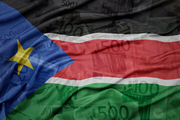 waving colorful national flag of south sudan on a euro money banknotes background. finance concept.