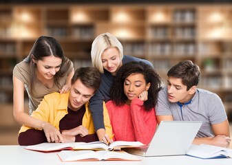 Happy group of young students studying in library