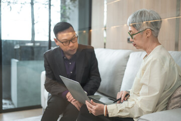 Asian businessman present start up project to expert investor, Teamwork group of multicultural business team solving problems, discussing business idea with skyscraper at modern business lounge