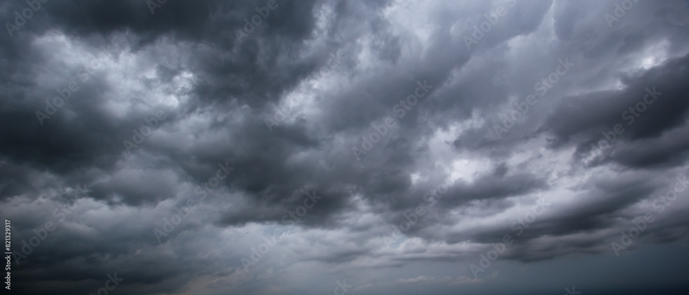 Poster The dark sky with heavy clouds converging and a violent storm before the rain.Bad or moody weather sky and environment. carbon dioxide emissions, greenhouse effect, global warming, climate change.