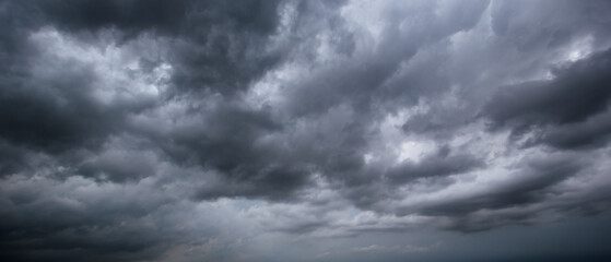 The dark sky with heavy clouds converging and a violent storm before the rain.Bad or moody weather sky and environment. carbon dioxide emissions, greenhouse effect, global warming, climate change.