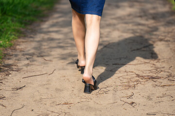 A woman's feet with the heels of her sandals slipped off