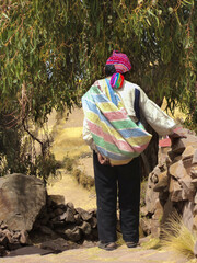 Peruvian rural man walking on a path with traditional dress