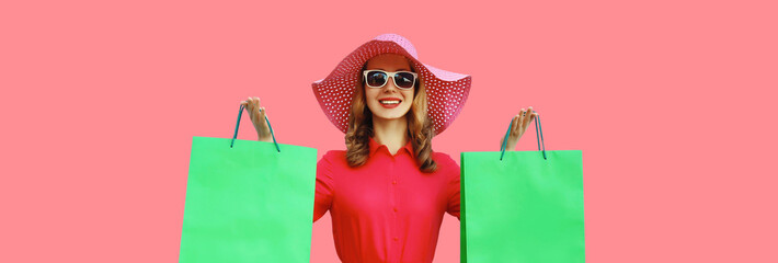 Portrait beautiful happy smiling young woman model posing with colorful shopping bags in summer hat