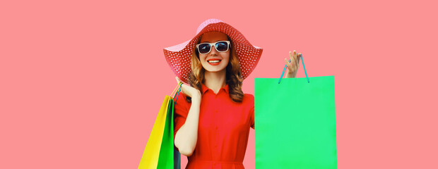 Portrait beautiful happy smiling young woman model posing with colorful shopping bags in summer hat