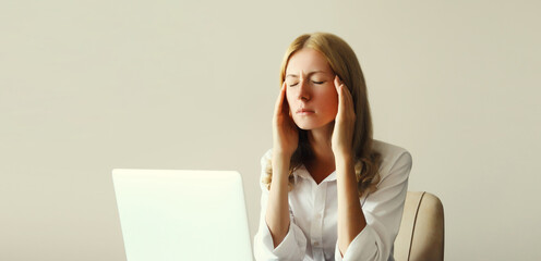 Tired overworked woman employee suffering from headache, migraine, working with laptop in office