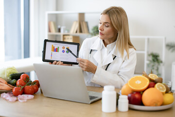 Efficient mature specialist in food providing nutritional guideline via graphs. Confident lady in...