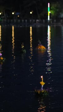 Vertical video. Krathongs floating on Lake Khao Tao reservoir at Loi Krathong festival in Thailand