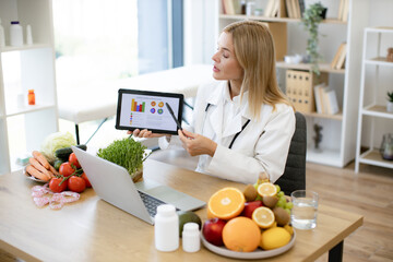Skillful female nutritionist explaining details of slimming program for client online. Focused...