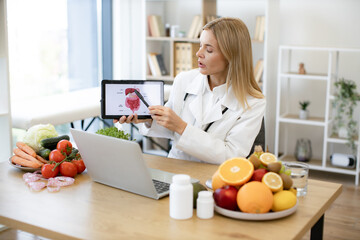 Mature female nutritionist talks about the treatment of gastrointestinal tract to patient during...