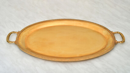 Golden antique tray on the light gray marble table texture. Selective focus.

