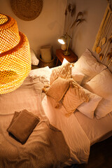 Bed with cozy pillows and blankets in bedroom at night, top view