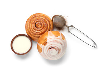 Cinnamon buns with cream and strainer on white background
