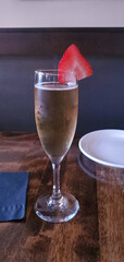 tall thin glass of champagne with a slice of strawberry on a table in a restaurant, champagne, sparkling wine, strawberry, alcohol, liquor, spirits, wine