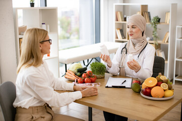 Muslim woman nutritionist makes plan for treatment of gastrointestinal tract using vitamins and...