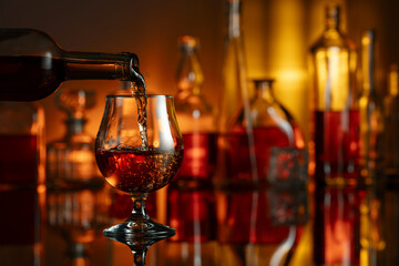 Pouring brandy from a bottle into a glass.