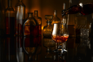 Brandy is poured from a bottle into a glass.