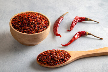 Red pepper flakes.Red chili peppers in wooden bowl on light blue background.Dried chili peppers