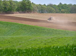 Obraz premium 土煙を上げるトラクター / Tractor making a cloud of dust