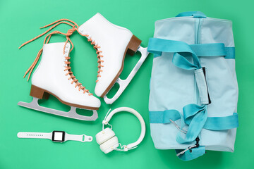 Sport bag with skates and headphones on green background