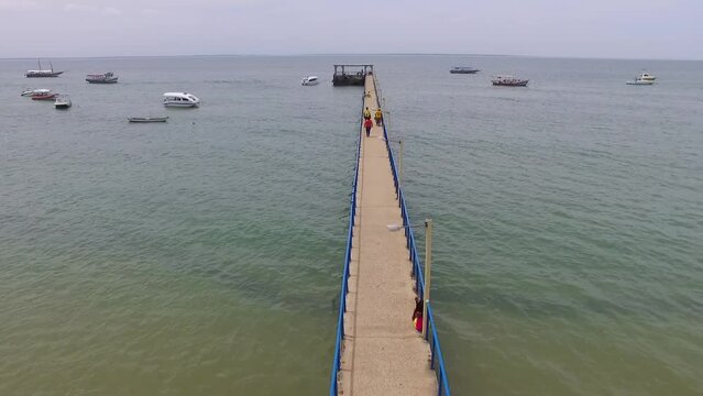 Drone mostrando o pier do porto de Barra Grande, Bahia, Brasil. Tomada a&eacute;rea em v&iacute;deo do alto da praia, com drone sobrevoando barcos e lanchas ancorados.