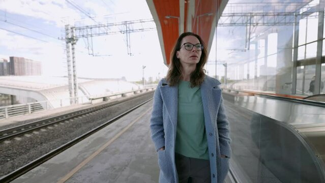 In the cozy atmosphere of public transport, a middle-aged woman in stylish glasses demonstrates her personality and fashionable taste.