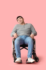 Young man in wheelchair on pink background. National Cerebral Palsy Awareness Month