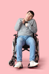 Young man in wheelchair on pink background. National Cerebral Palsy Awareness Month