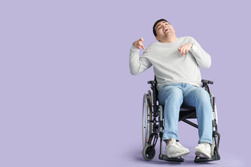 Young man in wheelchair on lilac background. National Cerebral Palsy Awareness Month