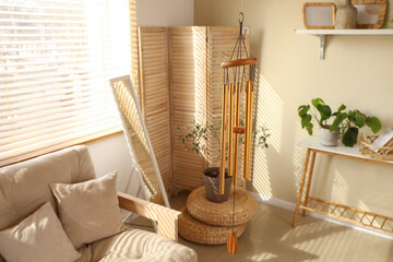 Golden wind chime hanging in light living room, closeup